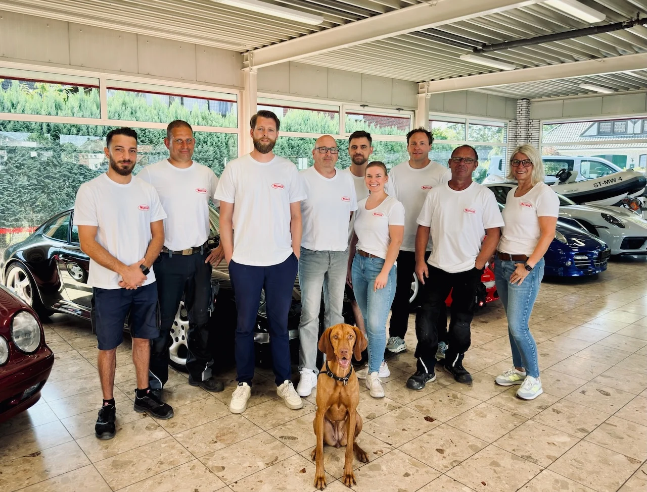 Team des Autohauses Wenner in weißen Hemden mit Hund