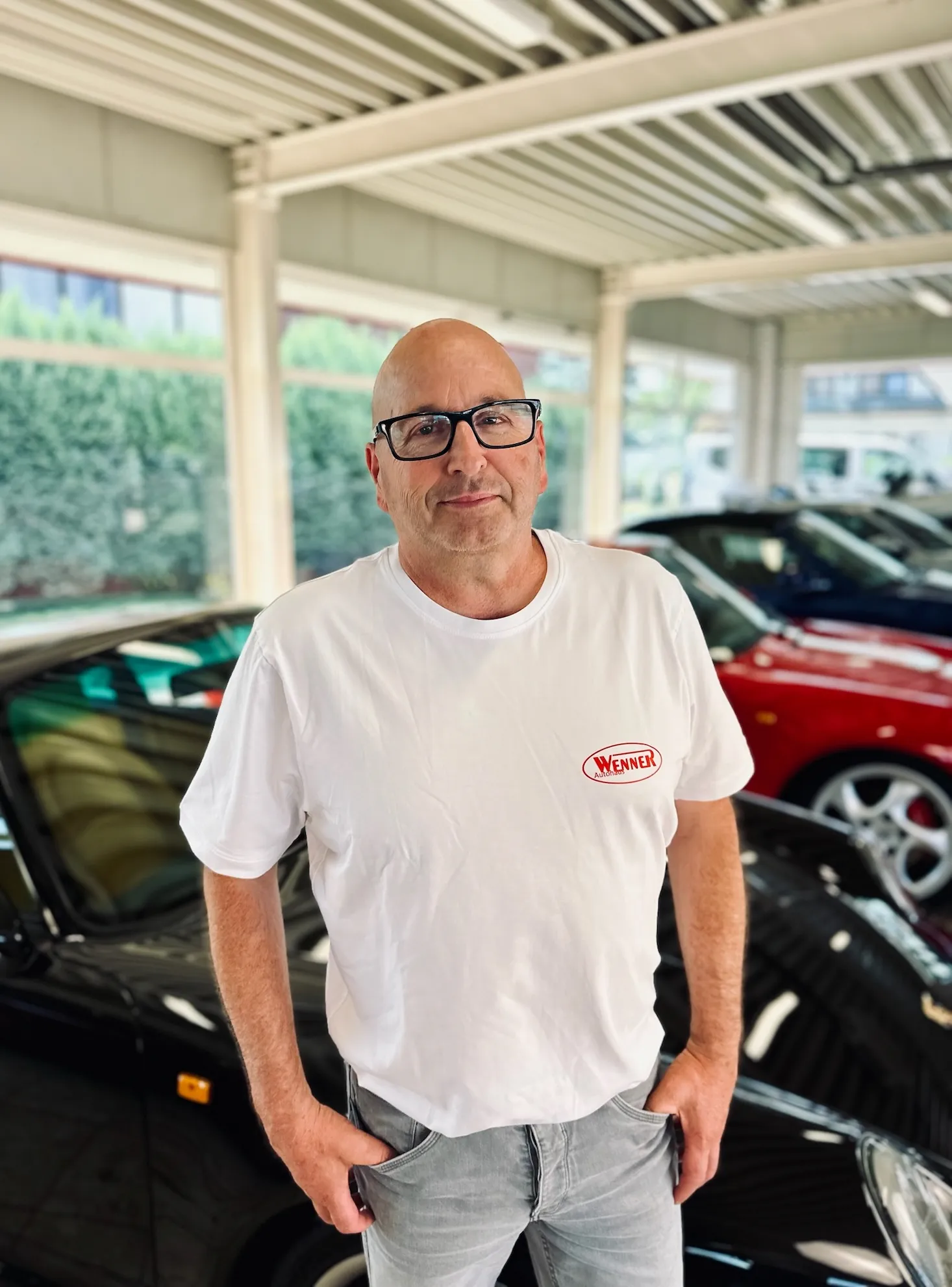 Teammitglied des Autohauses Wenner mit Brille im weißen Hemd